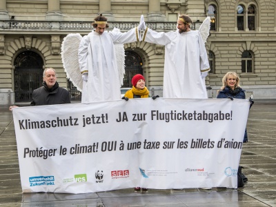 Zwei Klimaschutzengel übergeben die Botschaft für eine Flugticketabgabe an das Parlament